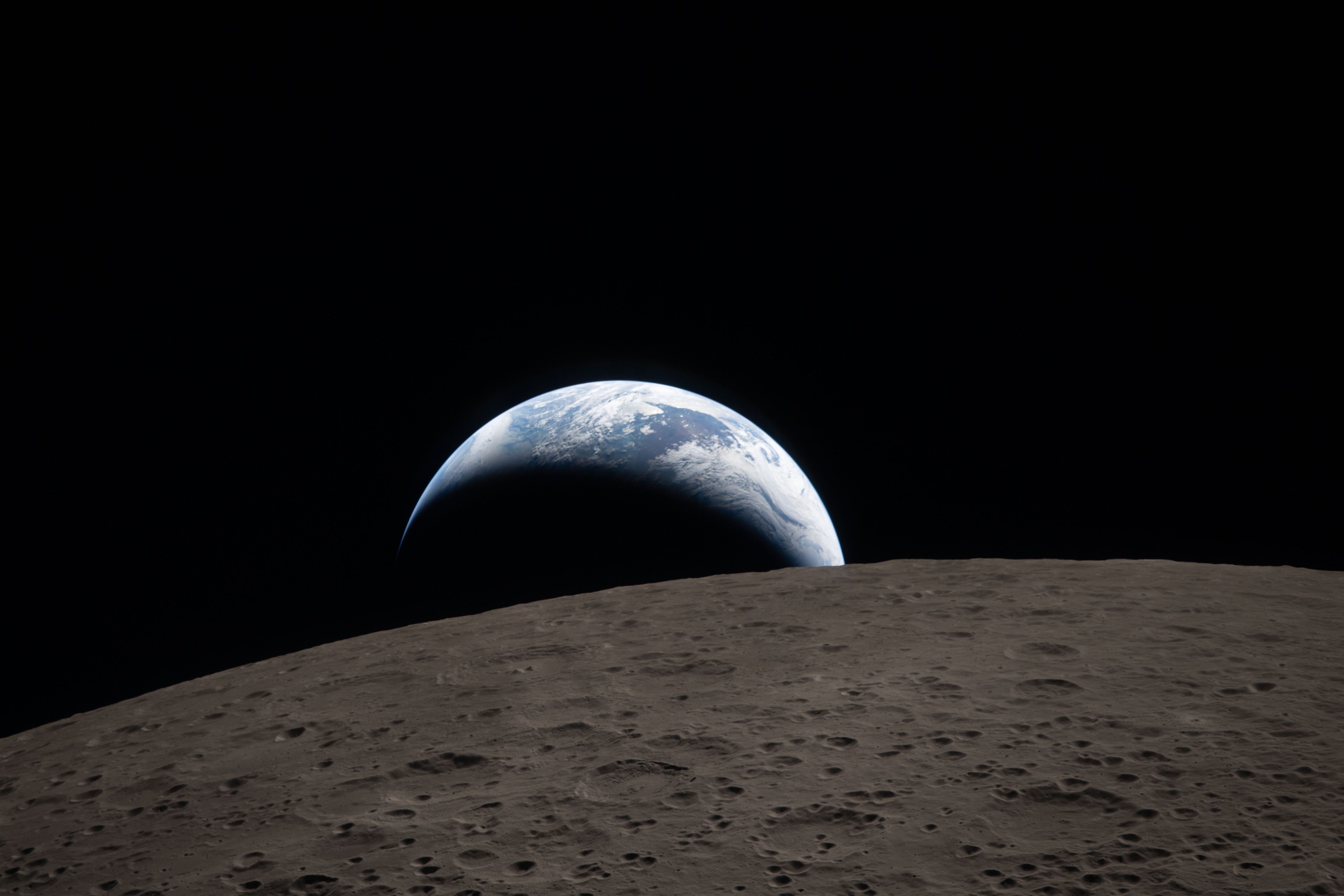A photo of the Moon from the Artemis II mission, with the Earth on the horizon.