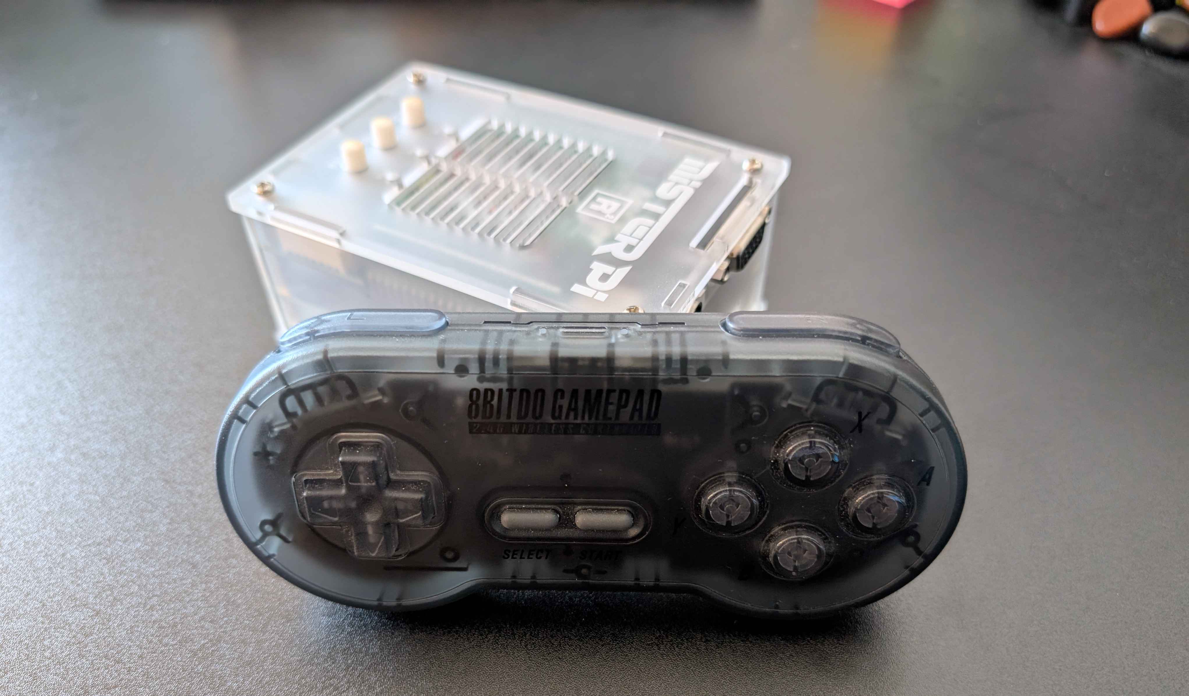 A photograph of a MiSTer FPGA device and a wireless controller
